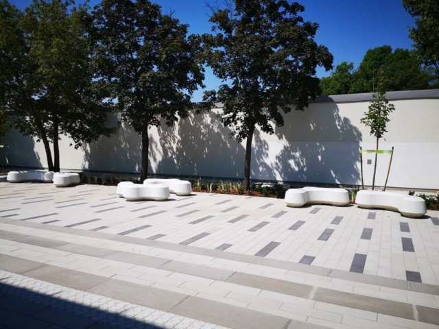 A white bench in a courtyard Description automatically generated